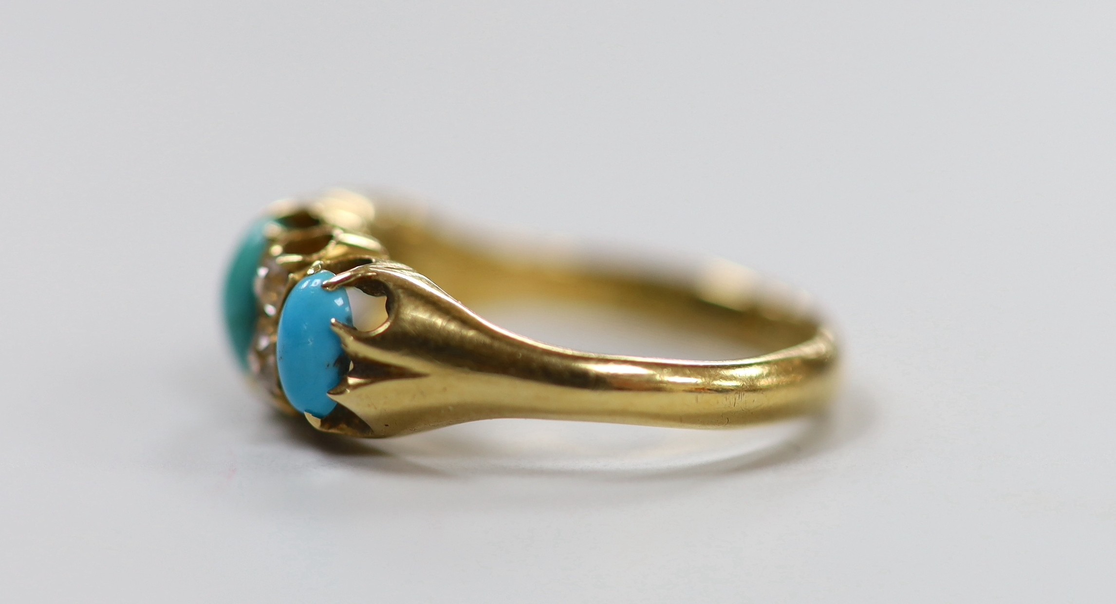 A late Victorian 18ct gold, three stone turquoise and four stone diamond set half hoop ring, size L, gross weight 3.9 grams.